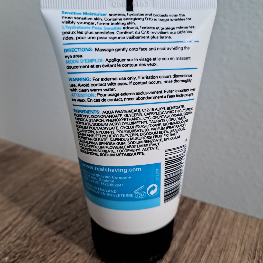 Close-up of a tube of lotion with text and branding on a wooden surface.