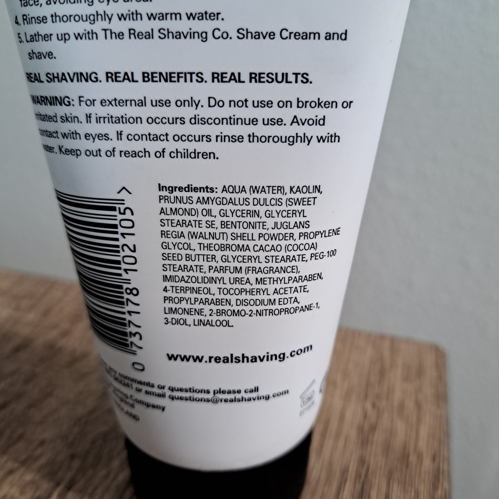 Close-up of a bottle label with text and a barcode on a wooden surface.